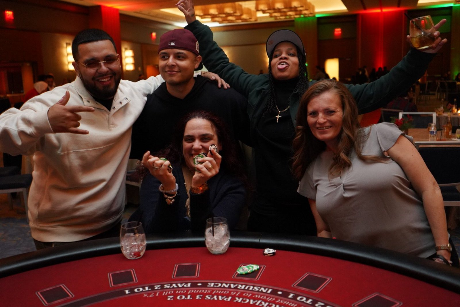 Employees laughing around a blackjack table at a casino theme corporate holiday party
