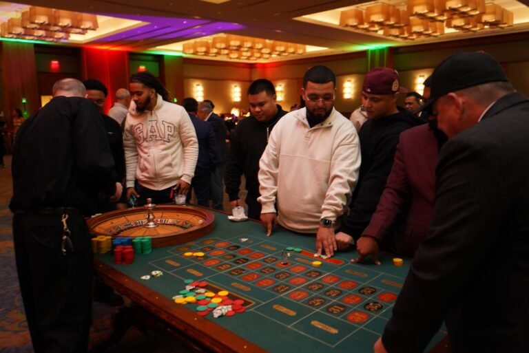 Guests networking around a roulette table at a corporate casino night