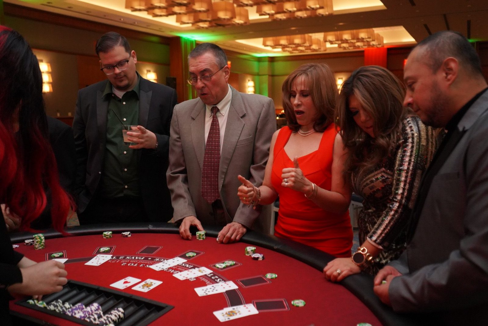 Vegas style decor with red and gold lighting at a casino theme corporate holiday celebration