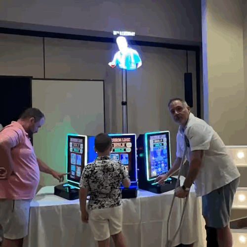 Award-winning 3-D hologram display featuring a glowing holographic figure above casino gaming stations at a party rental event