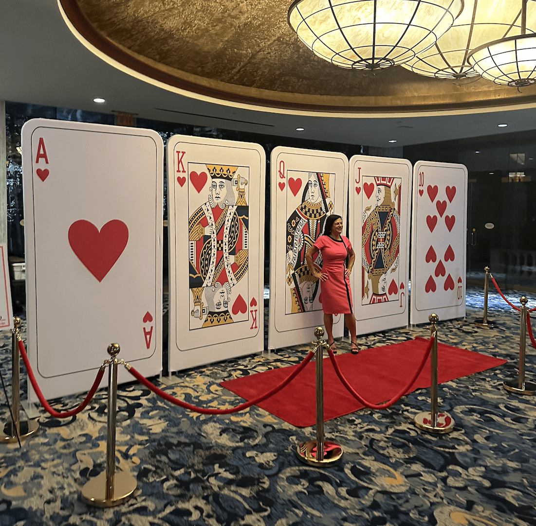 Giant oversized playing card backdrop decor with red carpet entrance for a casino theme party rental