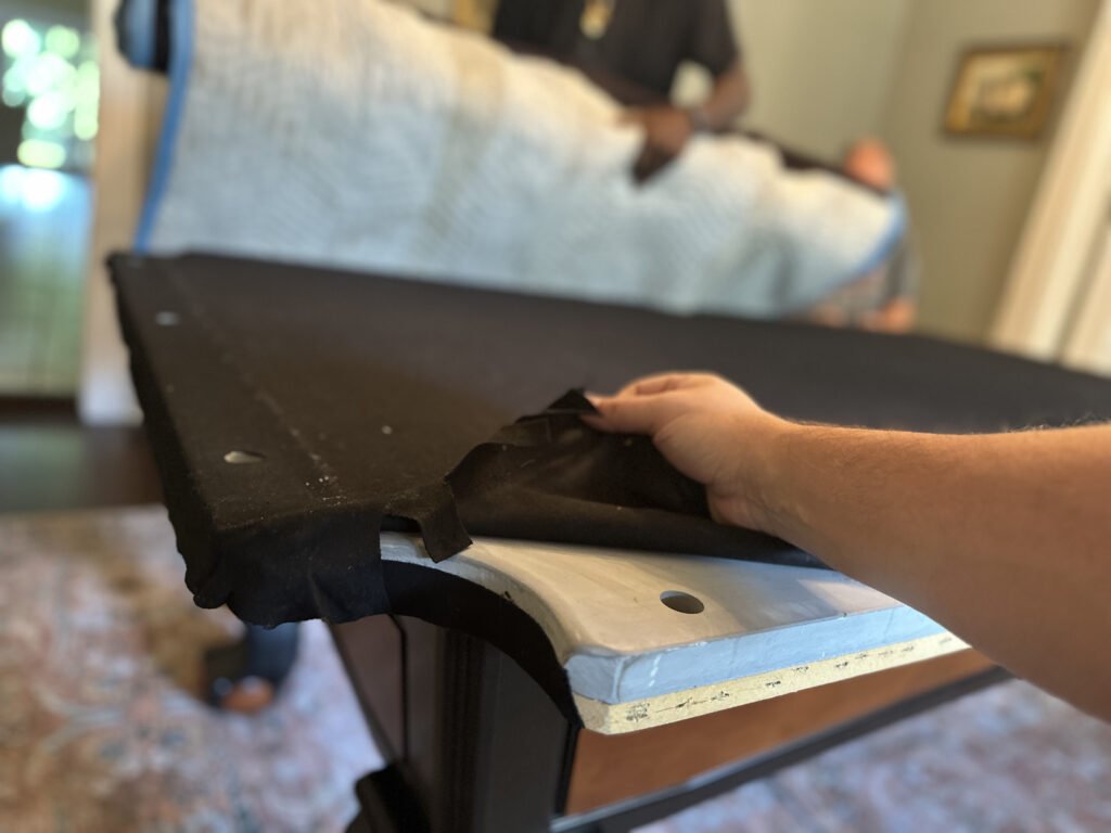 Pool table mover folding back the billiard cloth to separate the slate during a professional breakdown