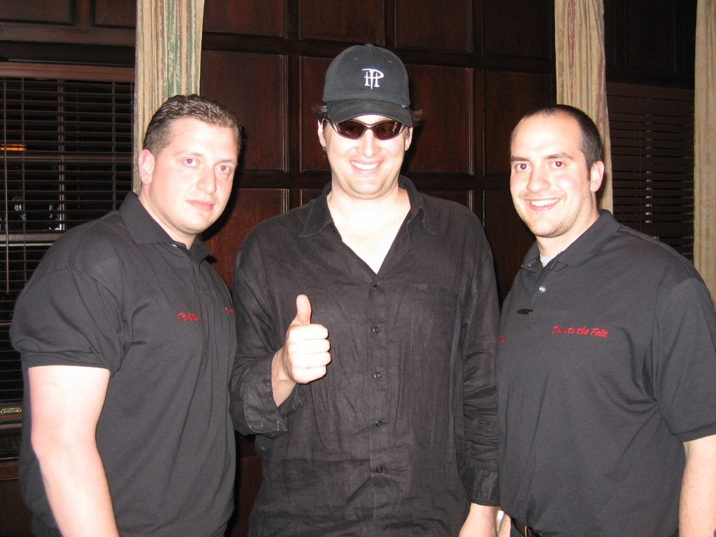 Guests and Phil Hellmuth posing together at a Manhattan corporate poker night